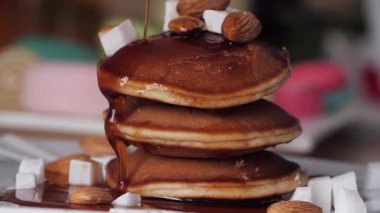 Kahvaltı. Şurup krep güzel ve yavaş dökülür. Yavaş çekim. Parlak bulanık arka plan. Lezzetli ve iştah açıcı. Tatlı gözleme akçaağaç şurubu dökün