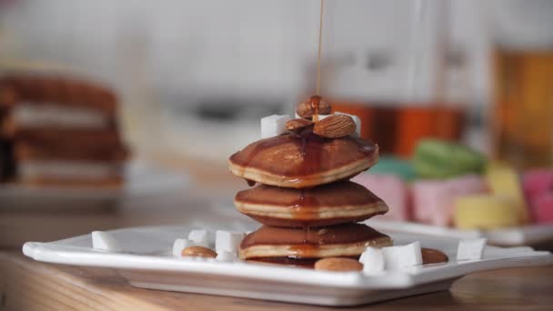 Ontbijt. Siroop giet op de pannenkoek mooi en traag. Slow Motion. Heldere onscherpe achtergrond. Lekker en smakelijk. Zoete pannenkoek pour esdoornsiroop — Stockvideo