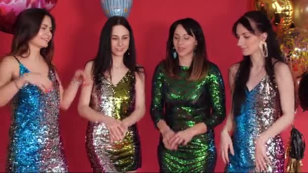 Дівчата в яскравих сукнях позують біля повітряних куль в студії — стокове відео