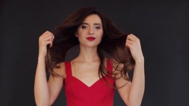 Güzel esmer kız her iki elinde onu uzun saç tutarak.