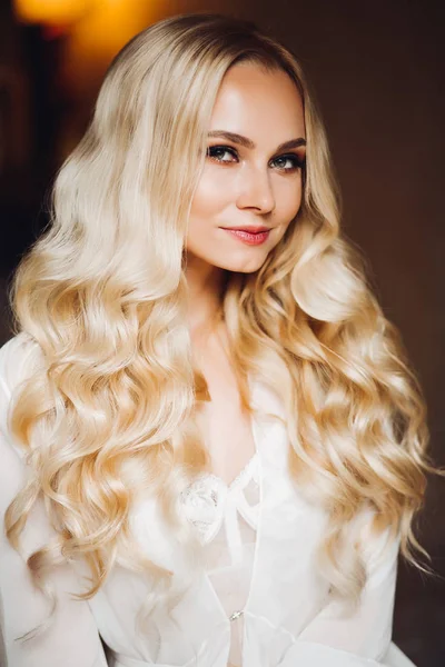 Güzel sarışın gelin yatak odasında poz kamera gülümseyen.