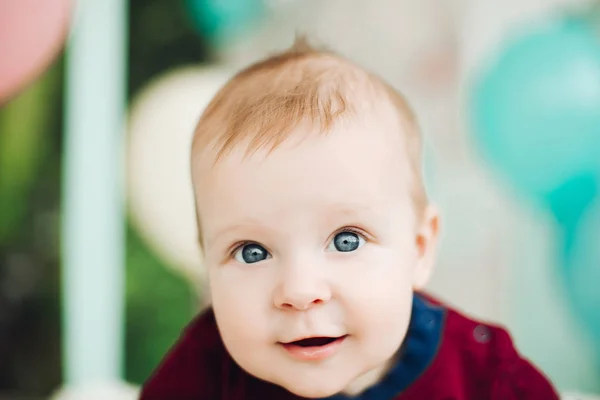 Doux petit garçon aux grands yeux bleus couché sur le ventre et souriant . — Photo