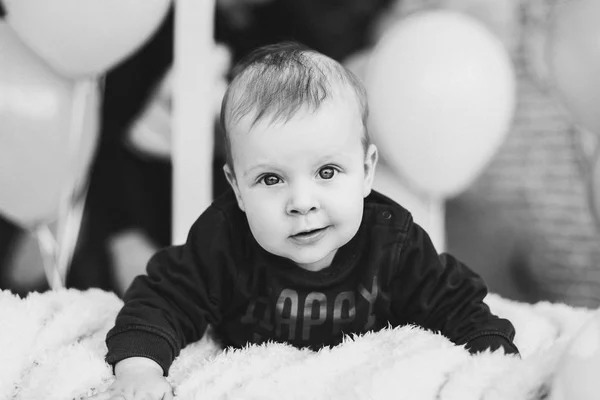 Menino doce com grandes olhos azuis deitado na barriga e sorrindo . — Fotografia de Stock