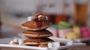 Pancake güzel lezzetli sağlıklı Kahvaltı. Kreplerin üzerine şurup dökülüyor. Şuruplu krep tatlısı. Parlak arka plan.