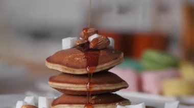 Pancake güzel lezzetli sağlıklı Kahvaltı. Kreplerin üzerine şurup dökülüyor. Şuruplu krep tatlısı. Parlak arka plan.