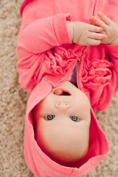 Uitzicht vanaf boven van lief klein meisje liggend op de vloer — Stockfoto