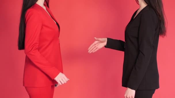 Dwaj partnerzy biznesowi potrząsając rękami w porozumieniu na czerwonym tle. — Wideo stockowe