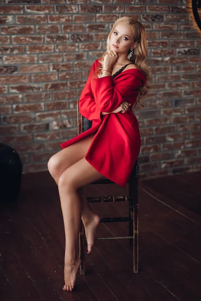 화려한 금발의 여자 에 빨강 드레스 보고 에 카메라. — 스톡 사진