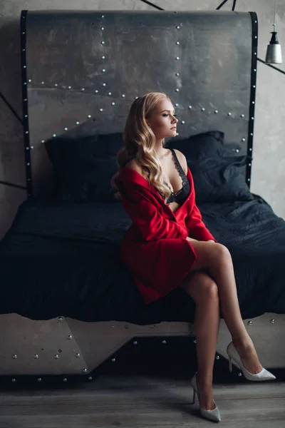 Krásná blondýnka v červených šatech, co se dívala na kameru. — Stock fotografie