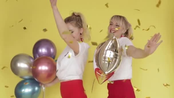 Glada tjejer som har fest och dans på gul bakgrund — Stockvideo