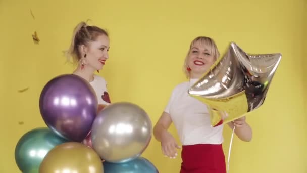 Chicas felices teniendo fiesta y bailando sobre fondo amarillo — Vídeos de Stock