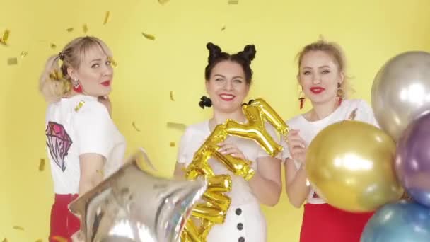 Boldog lányok, amelyek a párt és a tánc a sárga háttér — Stock videók