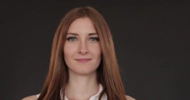 Uzun saçlı güzel kız düz ayakta ve gülümseyen.