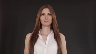 Uzun saçlı güzel kız düz ayakta ve gülümseyen.
