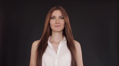 Uzun saçlı güzel kız düz ayakta ve gülümseyen.