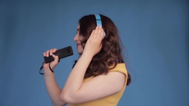 Chica joven feliz en grandes auriculares escuchando música . — Vídeos de Stock