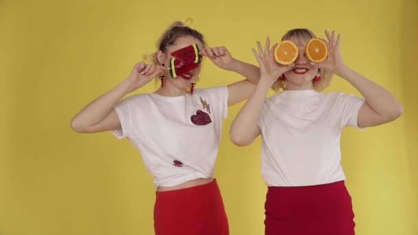 Meninas felizes fazendo festa e dançando em fundo amarelo — Vídeo de Stock