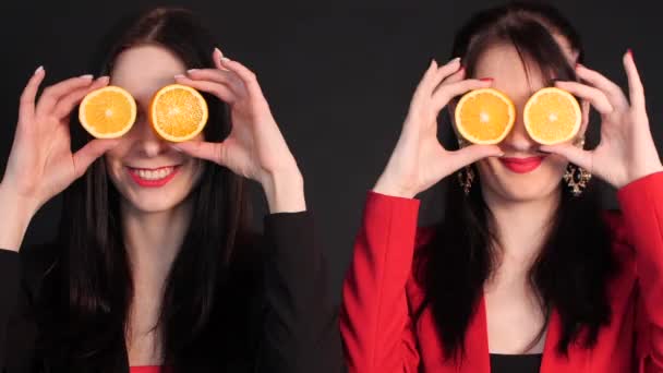Nők, akik félig narancsot tartanak a szemük előtt.. — Stock videók
