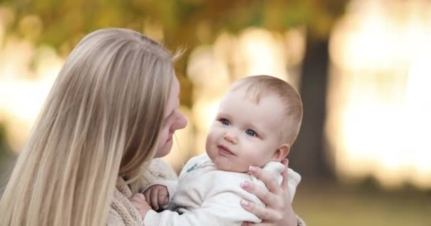 Liefdevolle moeder met een baby in Spring Park. — Stockvideo