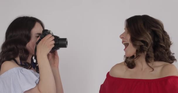 Zwei attraktive Mädchen, die Fotos vor der Kamera machen — Stockvideo
