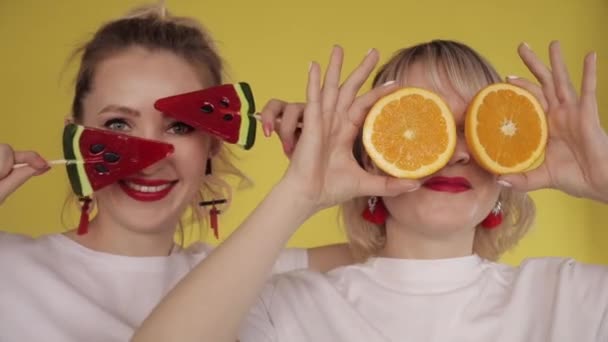 Meninas felizes fazendo festa e dançando em fundo amarelo — Vídeo de Stock