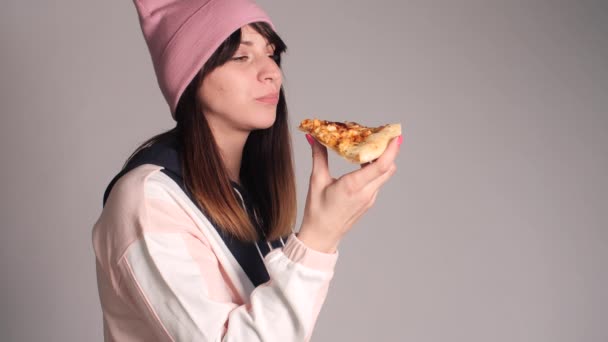 Young caucasian woman with tail eating piece of pizza. — Stock Video