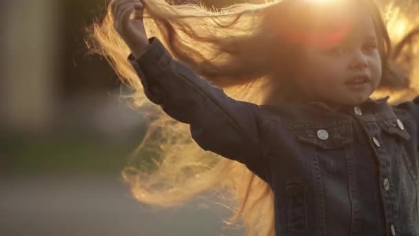 Mädchen wirbelt und posiert mit schönen langen Haaren im Park — Stockvideo