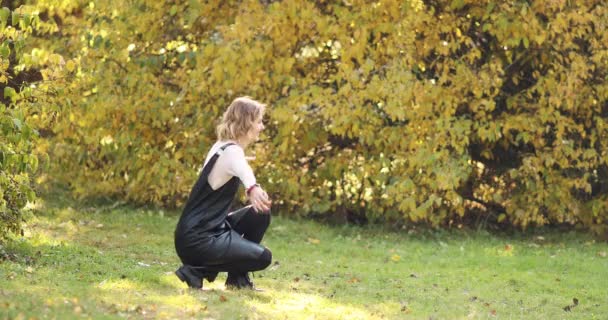 Mother holding her daughter on her arms and kissing in the garden. — Stock Video