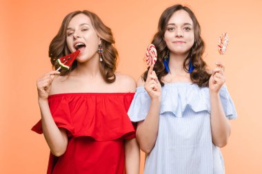Sevimli ikizler lolipop ile gözleri kapatArak ve poz