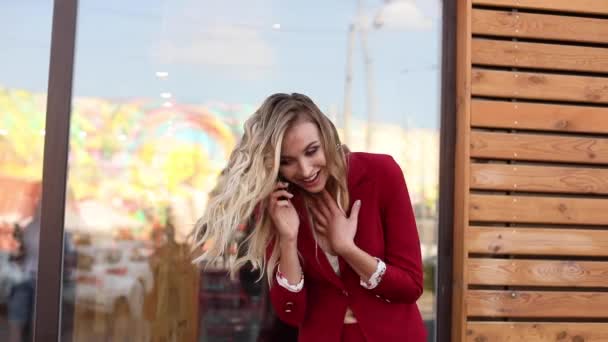 Elegante rubia en traje rojo inteligente usando teléfono y mensajería — Vídeos de Stock