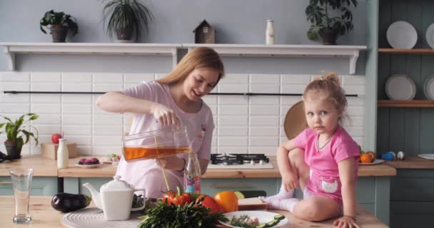 Beautiful mother cooking dinner on kitchen with little kid. — Stock Video