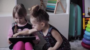 Katta oturan ve elektronik aygıtlar kullanarak komik çocuk.