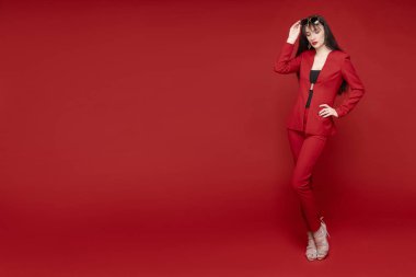 Kırmızı akıllı takım elbise poz çekici esmer yan görünümü