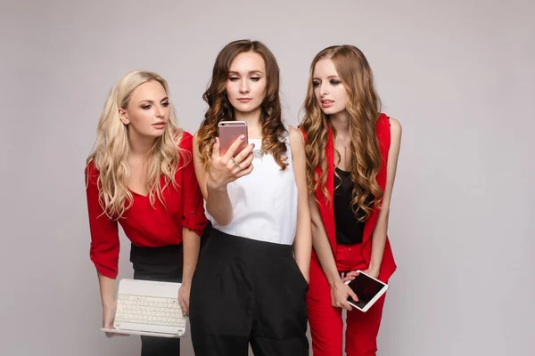 Стильна елегантна жінка в червоному костюмі використовує планшет з друзями . — стокове фото
