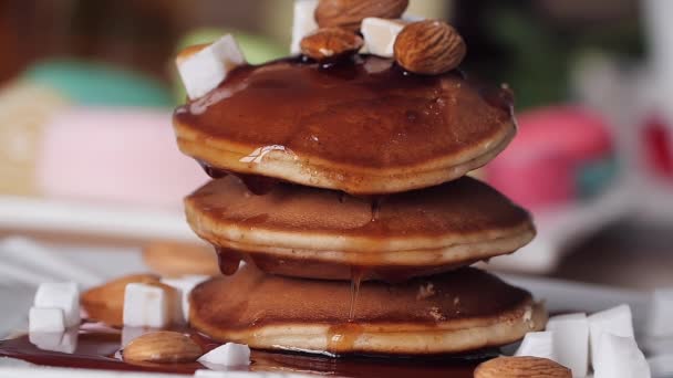 Ontbijt. Siroop giet op de pannenkoek mooi en traag. Slow Motion. Heldere onscherpe achtergrond. Lekker en smakelijk. Zoete pannenkoek pour esdoornsiroop — Stockvideo