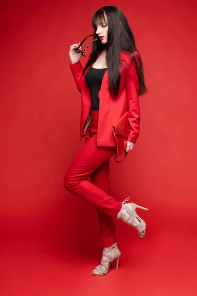 魅力的黑发女郎在红色智能西装的侧面视图 — 图库照片