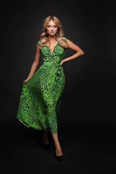 Тонка блондинка в зеленій сукні на чорному ізольованому фоні — стокове фото