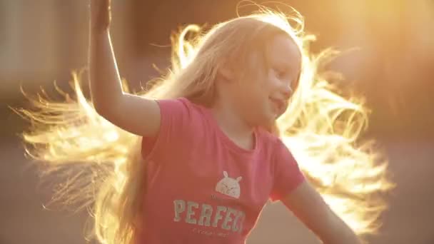 ベラルーシミンスク05 25 2019:女の子がぐるぐる回り、公園で美しい長い髪でポーズ — ストック動画