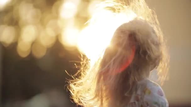Дівчина скручується і позує з красивим довгим волоссям в парку — стокове відео