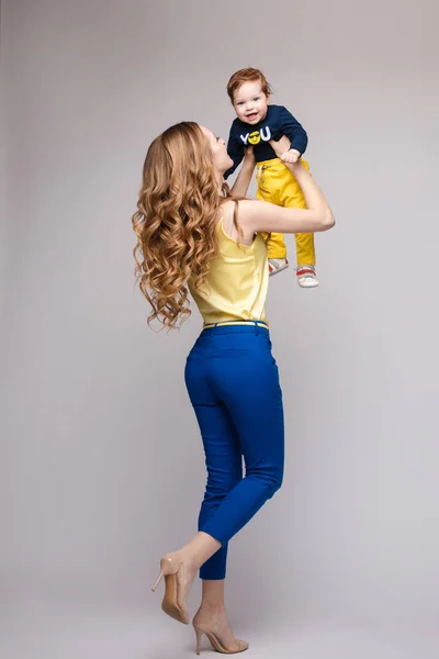 Unga och passar kvinna i casual kläder håller liten unge. — Stockfoto