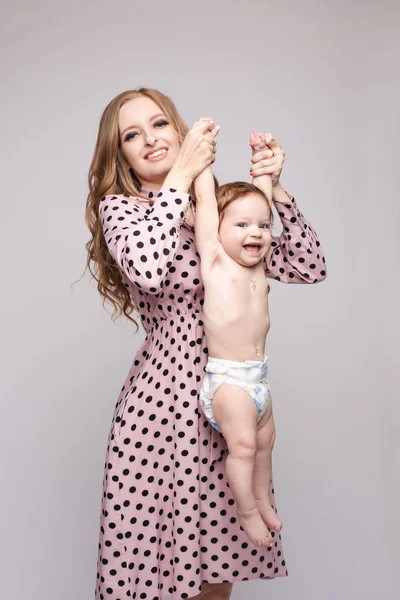 Young mother keeping child on hands and laughing — ストック写真