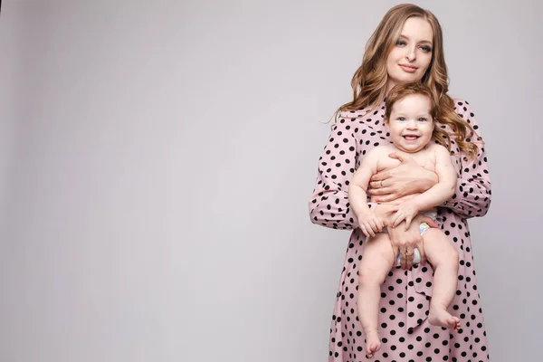 Joven madre manteniendo al niño en las manos y riendo — Foto de Stock