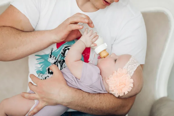 Gewas van kleine schattige baby liggend op vaders hand en eten. — Stockfoto
