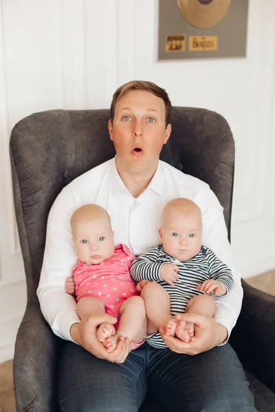 Funny förvånad pappa med två barn på knä. — Stockfoto