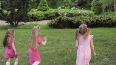 Bahçe ve oyun kabarcıklar oynarken mutlu küçük kızlar