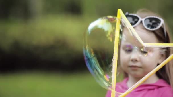 Schattig klein kind waait een bubbel in Park. — Stockvideo