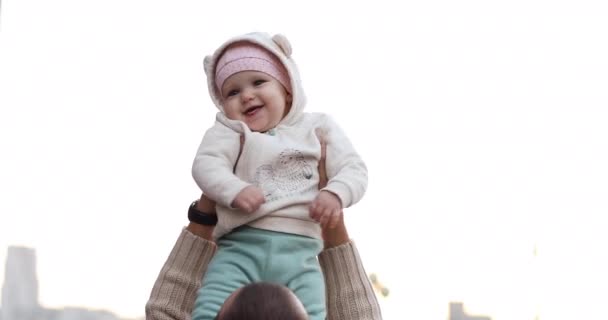 Schattige baby meisje in roze in Somebodys hands-up in hoog. — Stockvideo