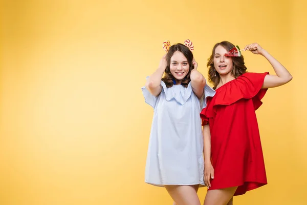 Retrato horizontal de duas jovens mulheres alegres se divertindo juntas no fundo — Fotografia de Stock