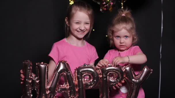 Jolie petite fille en robe rouge avec des ballons à air lettres heureuses . — Video