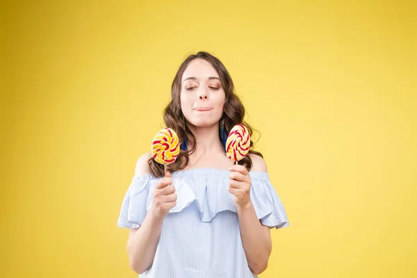 Modische junge Frau mit Lolipop in den Händen im Hintergrund — Stockfoto